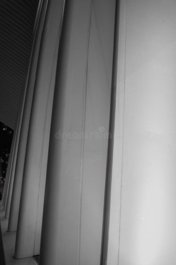 Vertical greyscale shot of a modern architectural structure with concrete columns stock images