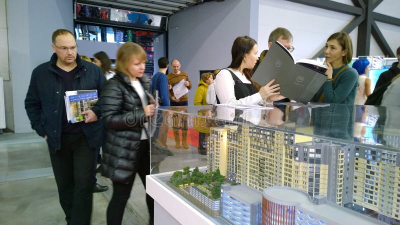 Visitors and buyers in Real estate exhibition in expo centre. Layout of modern  residential building. Sale and rental of apartment. St. Petersburg, Russia royalty free stock image