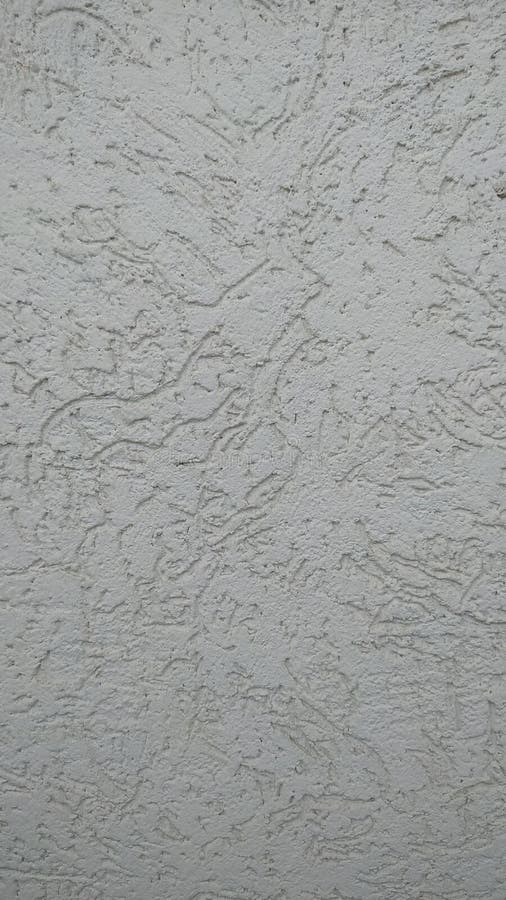 The wall is covered with decorative plaster with an imitation of bark beetle painted in gray stock image