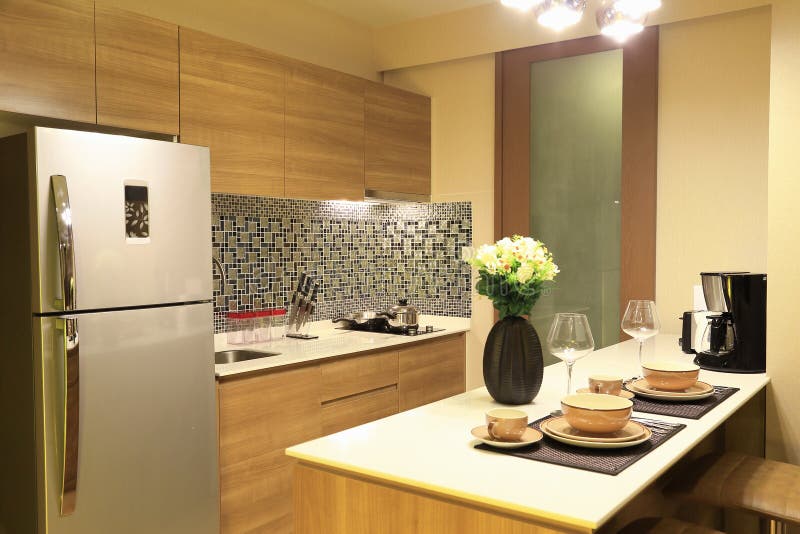 Warm tone of luxury interiors design of the kitchen in condominium, as kitchen design background. Warm tone of luxury interiors design of the kitchen in stock images