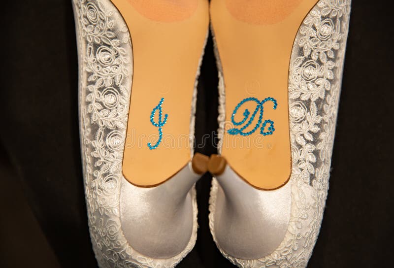 White heels with I do written on the bottom in blue. For a wedding stock image