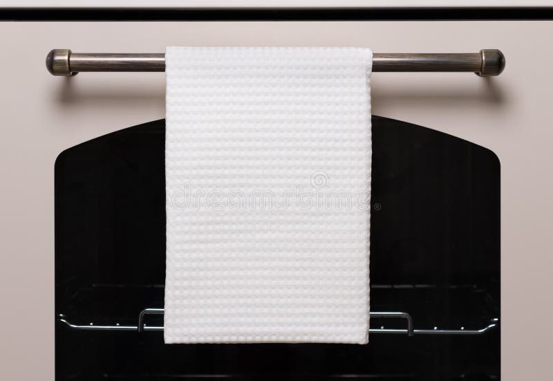 White kitchen towel hangs on the oven handle, product mockup.  stock photo