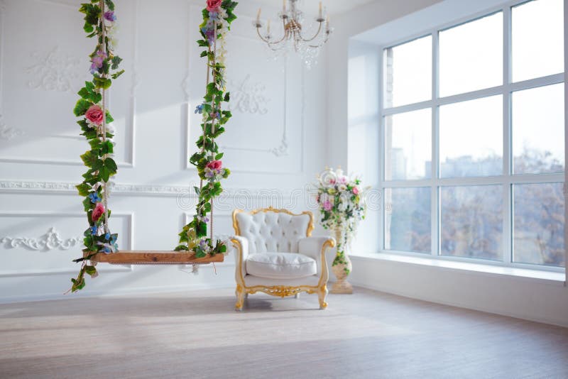 White leather vintage style chair in classical interior room with big window and spring flowers.  royalty free stock images