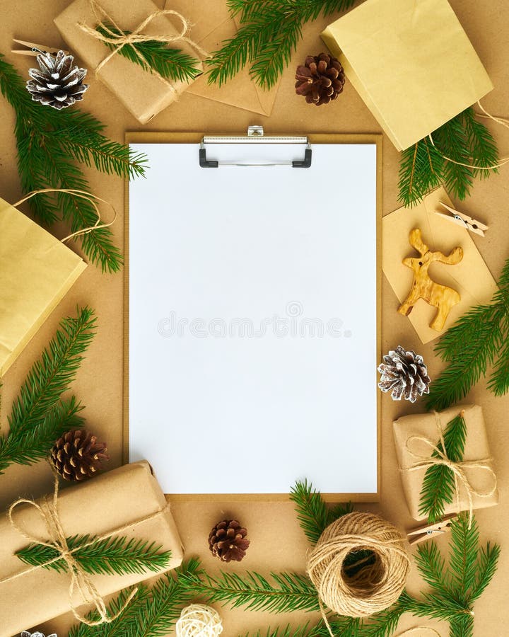 White open blank on clipboard and Christmas decoration lying on beige craft paper background, flat lay, copyspace. Hand crafted, stock photos