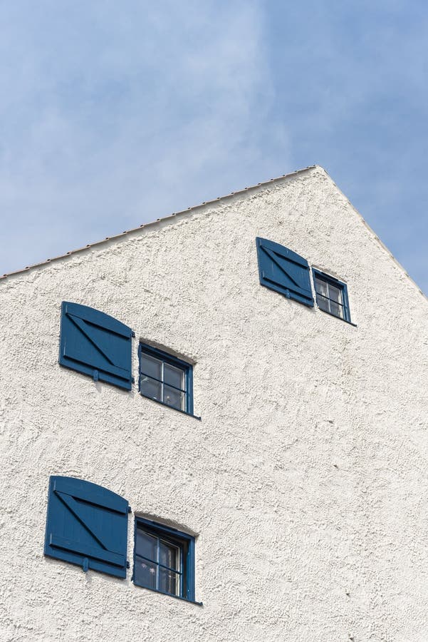 White plastered gable facade Ystad Sweden. White plastered gable facade with blue windows and shutters on residential house in medieval Ystad in Skåne, Sweden stock photo