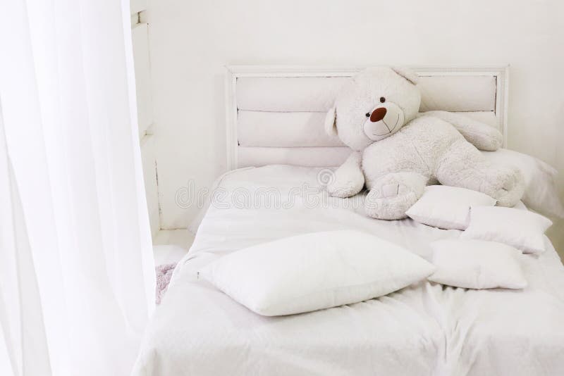 White room interior with bed, window, pillows and bear. White bedroom interior with bed, window, pillows and bear stock photography