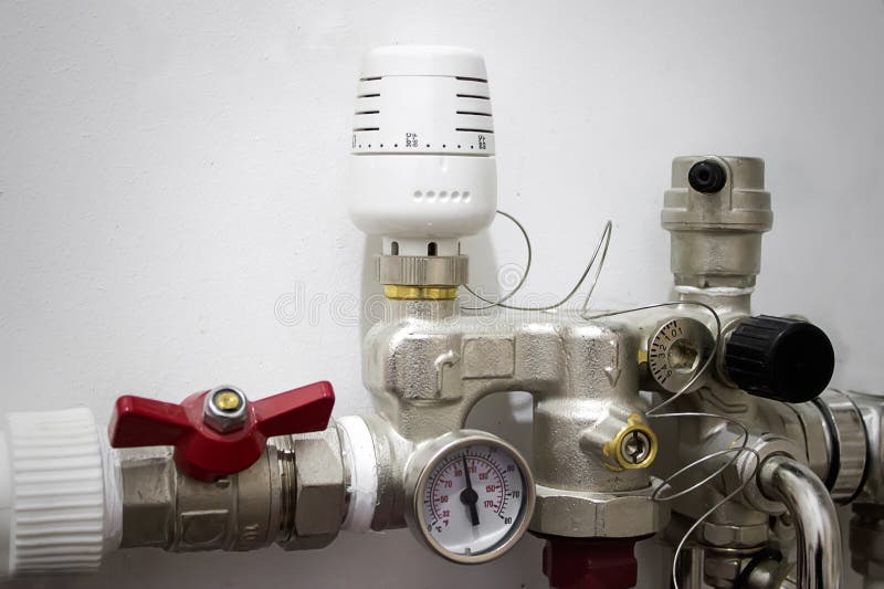 White switch and underfloor heating thermostat on a white concrete wall in the boiler room of a private house. Close-up of a stock photos