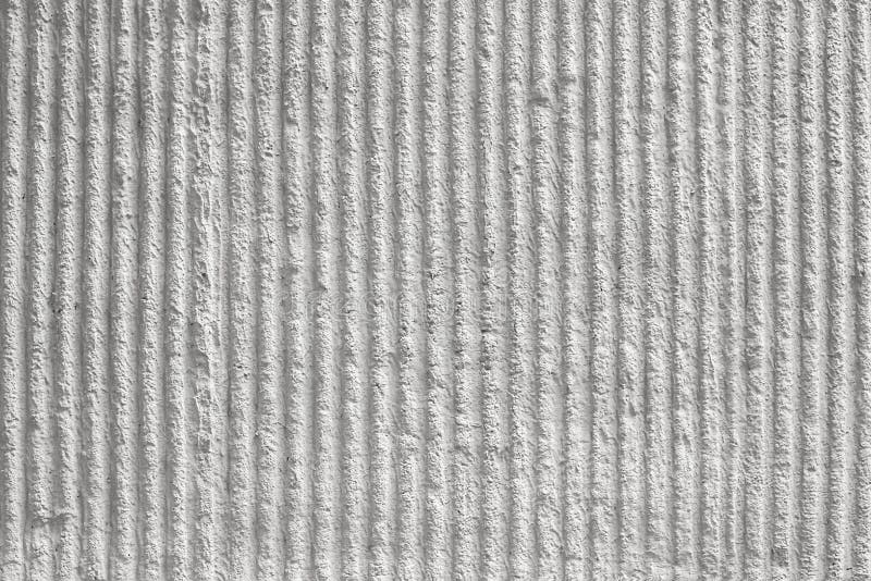 White wall with a decorative plaster and vertical stripes. texture, background. Surface of the wall with a decorative white plaster. Textured concrete wall with stock photo