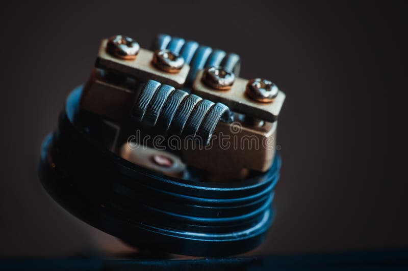 Smokes man vape. Winding close-up for electronic cigarettes from nichrome, fecral. vape. Staggerton Fused Clapton Coil on Dripper for vaping royalty free stock image