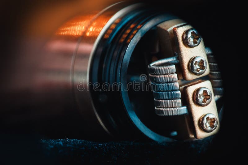 Smokes man vape. Winding close-up for electronic cigarettes from nichrome, fecral. vape. Staggerton Fused Clapton Coil on Dripper for vaping royalty free stock photo