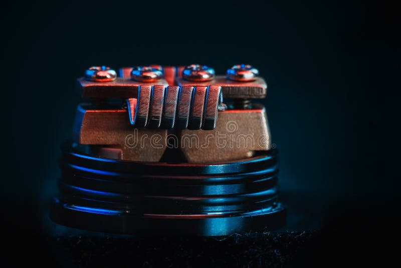 Smokes man vape. Winding close-up for electronic cigarettes from nichrome, fecral. vape. Staggerton Fused Clapton Coil on Dripper for vaping stock photography