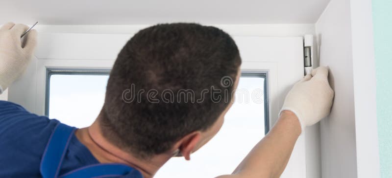 A window installation wizard adjusts the plastic window, warranty claim, rear view stock photo