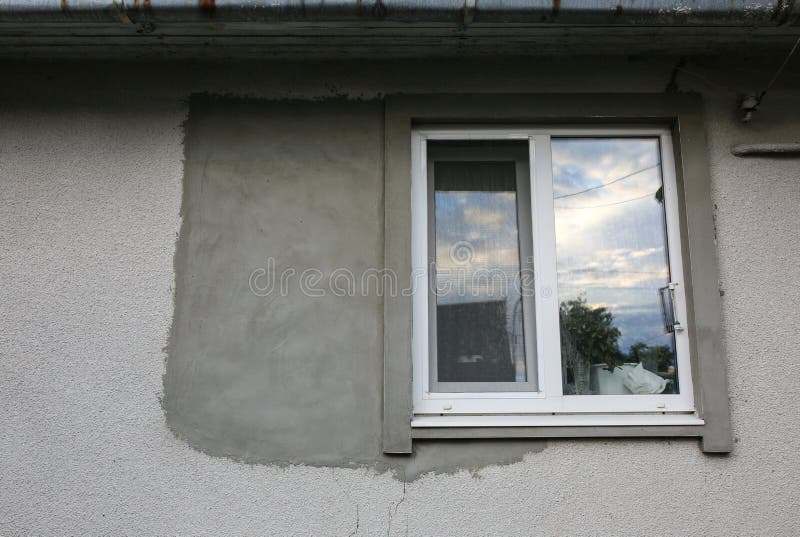 Window in the maintenance decorating process. Concrete on the grey house.  stock image