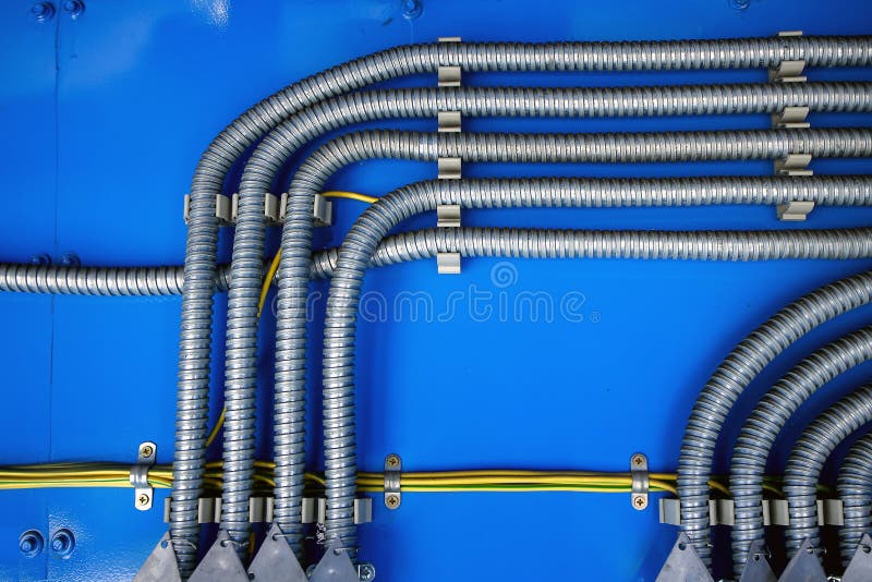 Wiring, distribution of wires in a metal corrugation on a blue background stock photography