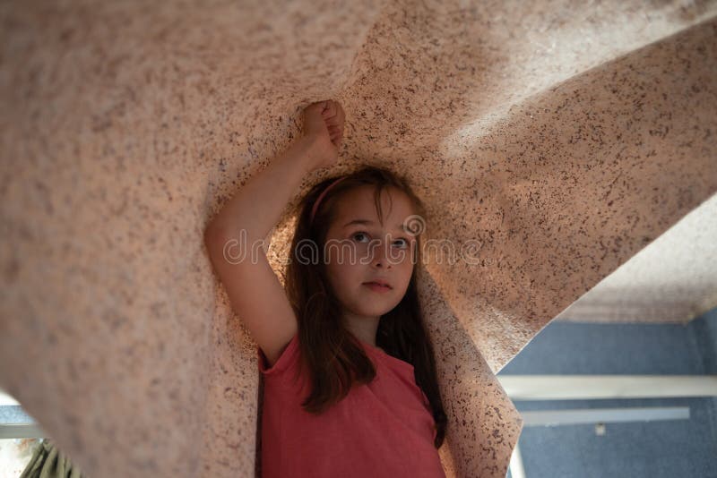 Woman hanging wallpaper motif. Teen girl helps to glue wallpaper on the ceiling. A girl of 9 years helps parents make repairs in the room. Help child. Teenager royalty free stock photo