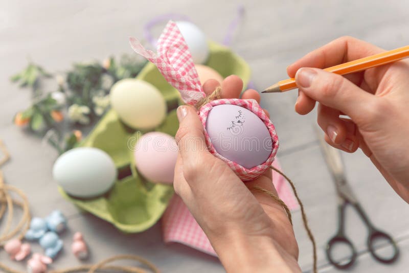 Woman makes cute decorative eggs for easter holiday. do-it-yourself easter gifts concept. cute pastel colored eggs royalty free stock images