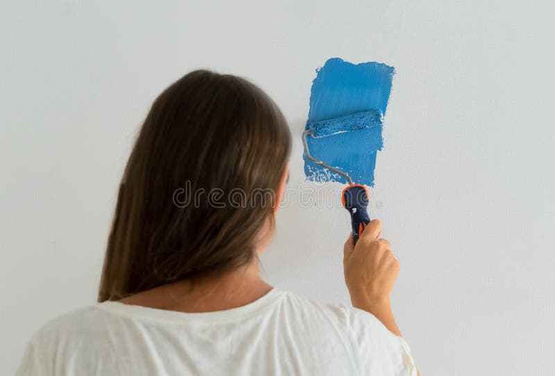 Woman painting wall stock photography