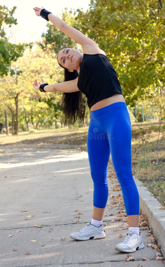 Woman working out doing stretching exercises stock photo