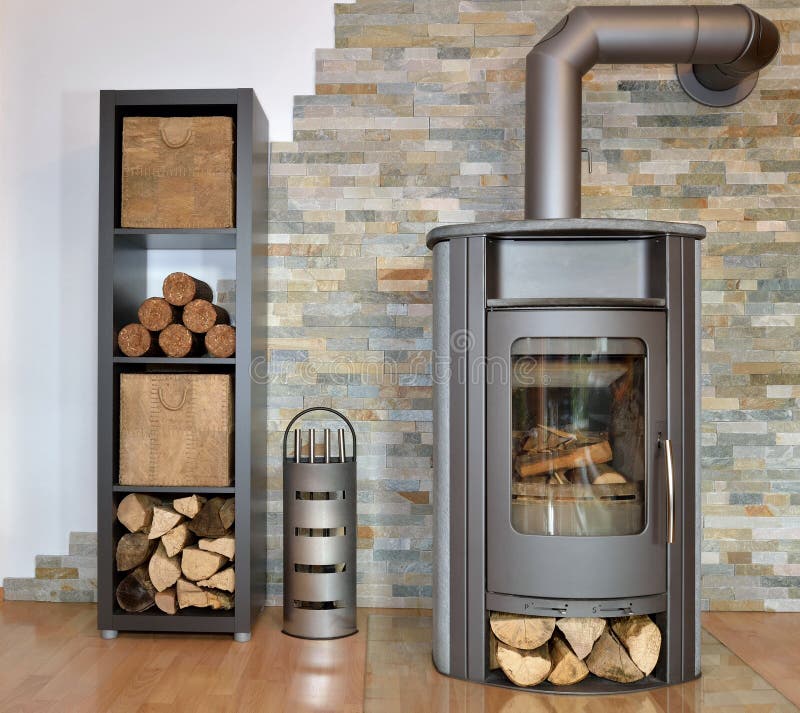 Wood fired stove. With fire-wood, fire-irons, and briquettes from bark bevore ignition stock image