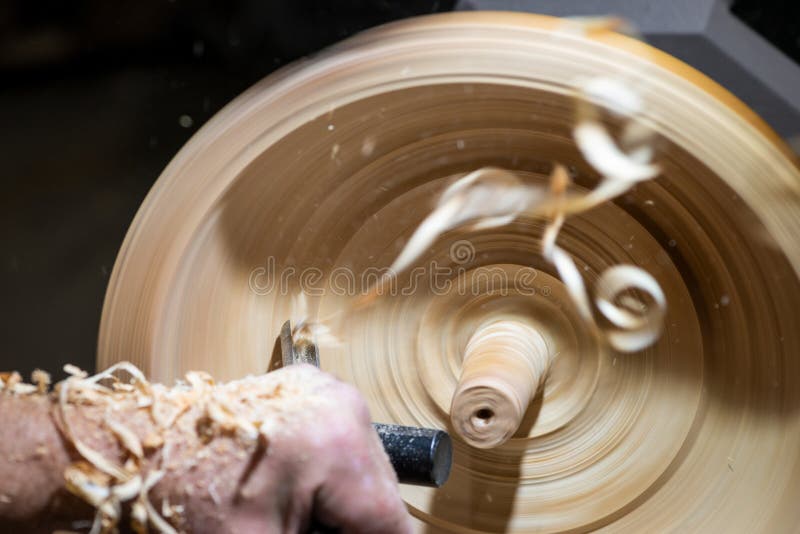 Wood shavings in motion while turnery of a wooden bowl royalty free stock image