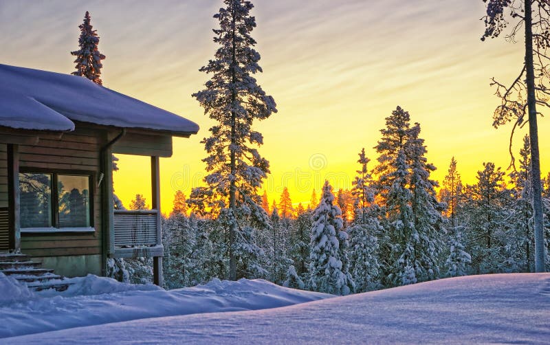 Wooden cottage house at winter sunset. In Finland royalty free stock photography