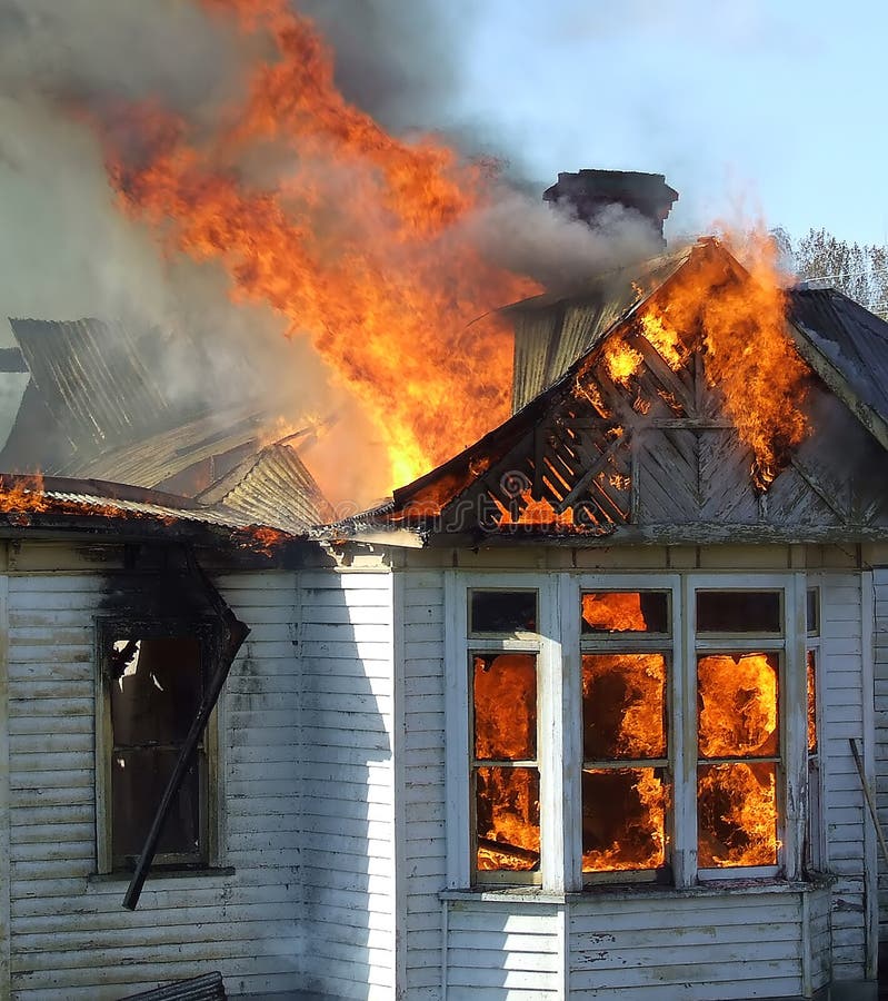 Wooden house on fire. Exterior view of wooden house on fire stock images