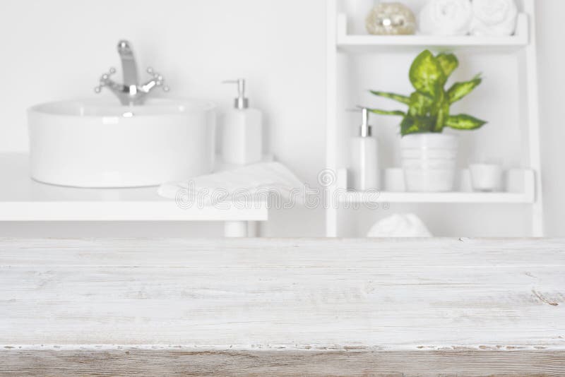 Wooden table in front of blurred white bathroom shelves background stock images