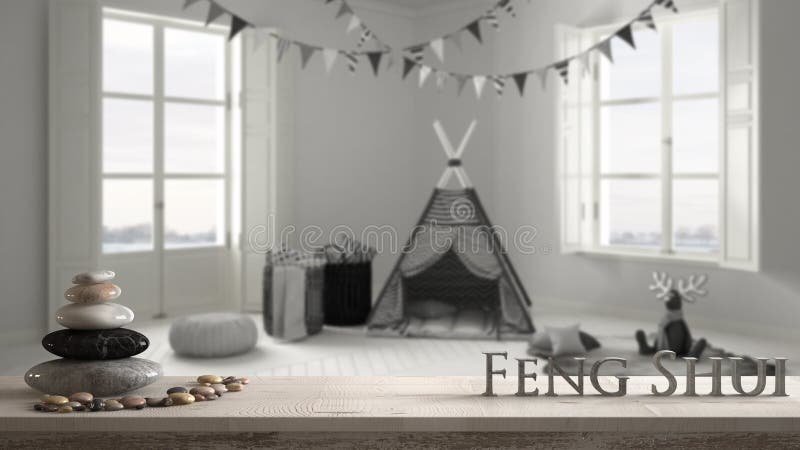 Wooden vintage table shelf with pebble balance and 3d letters making the word feng shui over blurred child room with furniture stock image