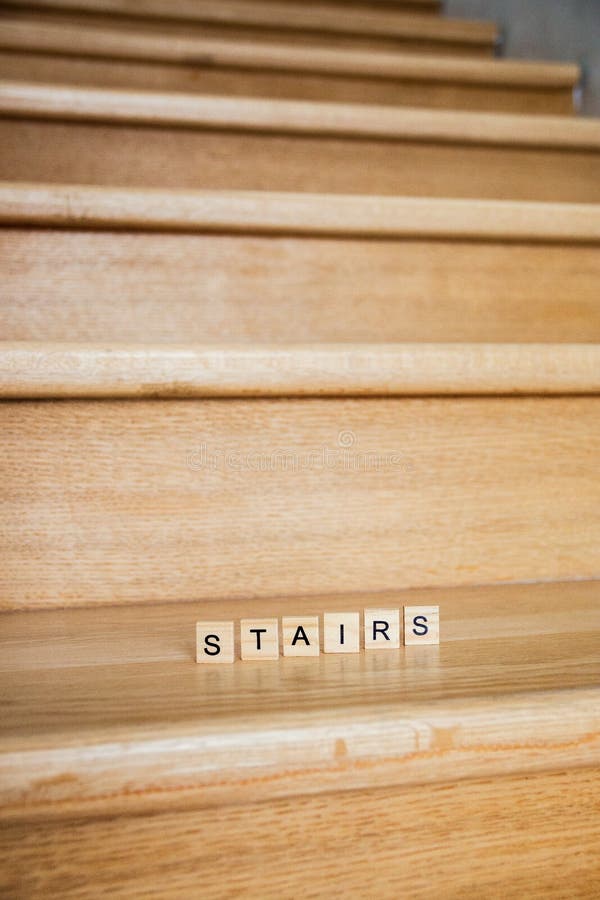 The word Stairs is written in cubic letters on a wooden stairs in house.  royalty free stock photo