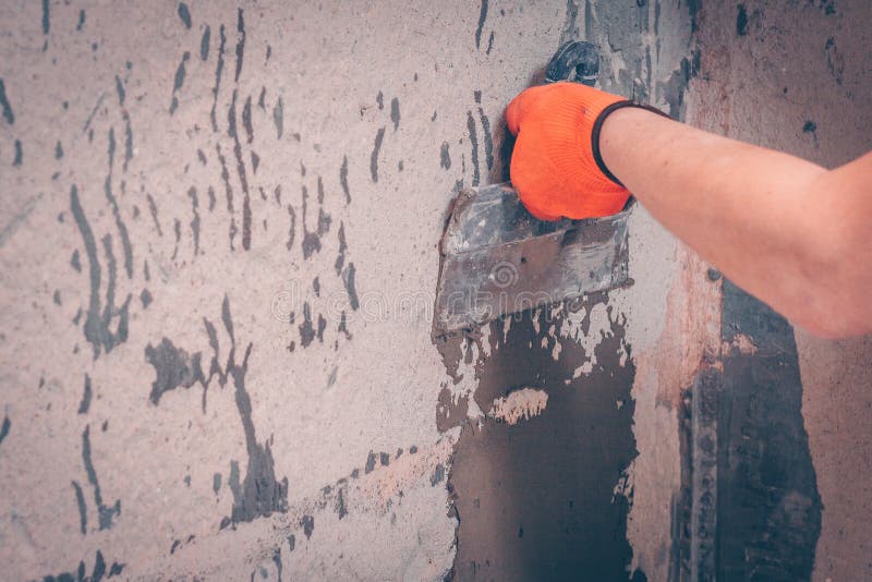 The worker aligns the wall. With a tile adhesive applying it with a spatula, preparation for tiling royalty free stock photography