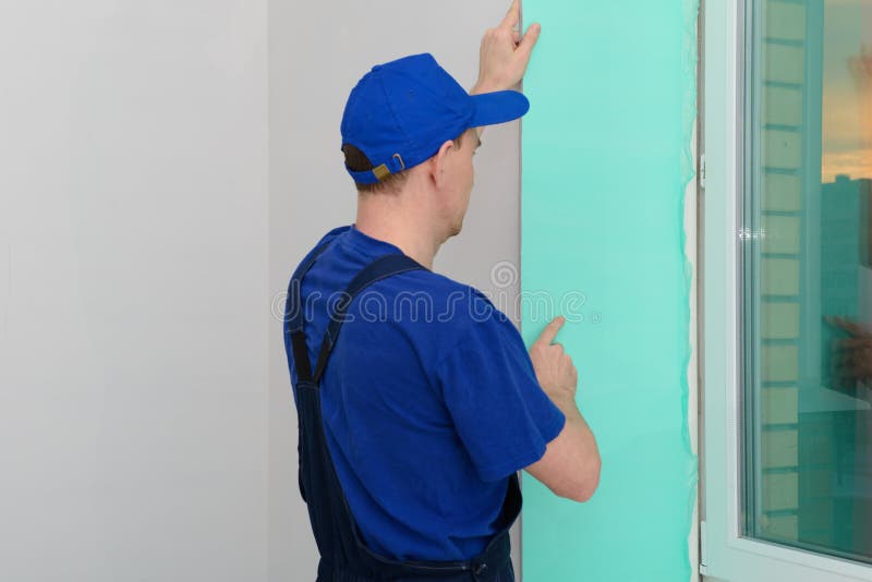 Worker installs sandwich panels for slopes stock images