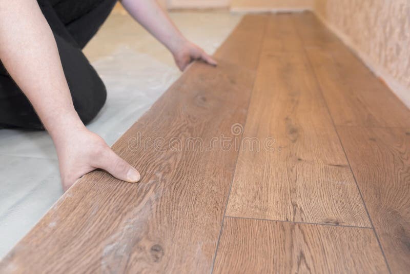 Worker installs a wooden parquet floor. Repair concept royalty free stock photo