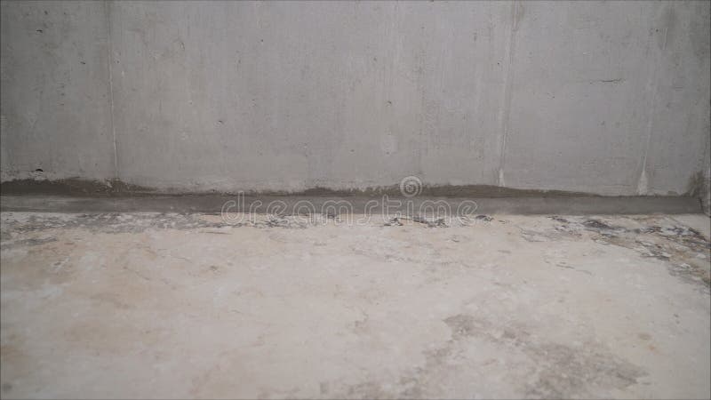A worker vacuums a concrete floor. Construction services for cleaning the sleeve with an anchor bolt. dust removal with a vacuum. Construction services for stock photo