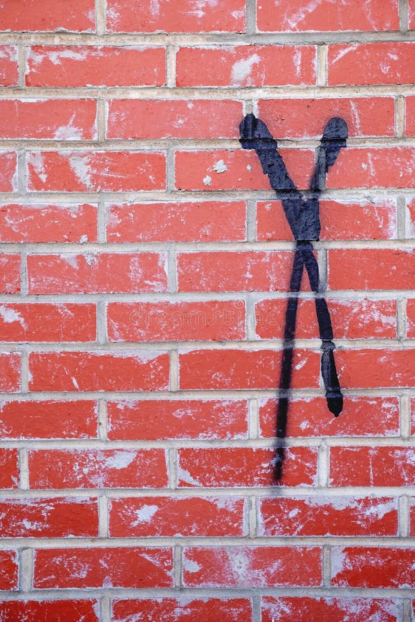 X Always Marks The Spot. A painted black X on a red brick with concrete grout building stock photography