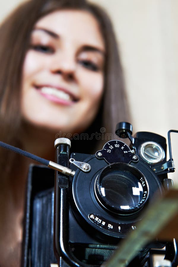 Old camera and young girl. Young girl with big old camera rarity stock photo