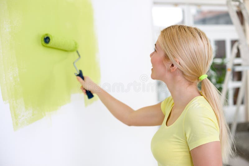 Young woman painting wall royalty free stock photo
