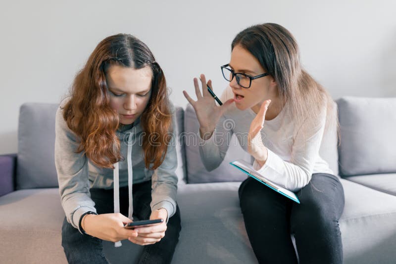 Young woman professional psychologist talking with teenager girl 14, 15 years old sitting in office on sofa. Mental health of. Young women professional stock image