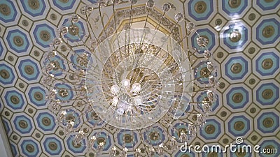 Beautiful chandelier with bulbs on ceiling. Elegant chandelier with hanging crystal balls and illuminated bulbs looking beautiful on pattern ceiling in a stock video
