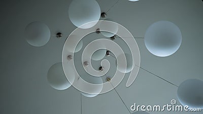Beautiful chandelier in the form of round white balls hanging on white ceiling.  stock footage