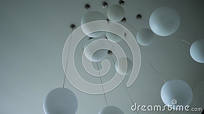 Beautiful chandelier in the form of round white balls hanging on white ceiling.  stock footage