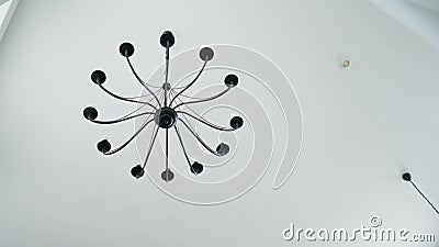 Beautiful chandelier in the loft hanging from the ceiling on a white background. Close-up stock footage