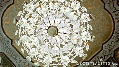 Beautiful hanging crystal chandelier on ceiling. Smooth camera track right stock video footage