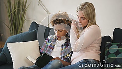 Happy family is reading together story from book which holding little boy. stock footage