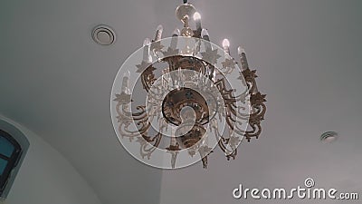 A large beautiful chandelier hangs from the ceiling of an Orthodox Christian Church. T. He camera revolves around the chandelier stock footage