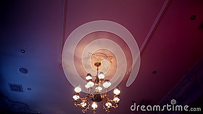A passageway with a camera under a large beautiful chandelier and a painted ceiling. The ceiling is illuminated with pink light stock video