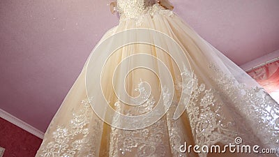 White wedding dress hanging in the room to bride on the chandelier. beautiful white ball gown hanging from the ceiling. White wedding dress hanging in the room stock footage