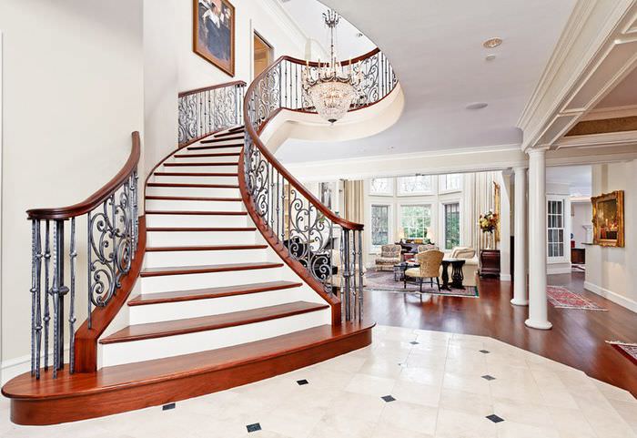 Интерьер холла загородного дома с лестницей в классическом стиле