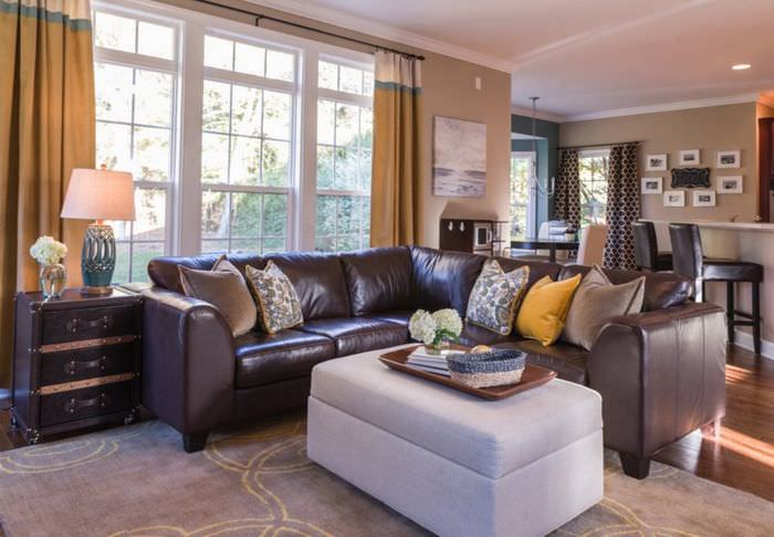 Интерьер гостиной загородного дома с коричневым диваном