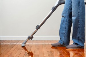 Man Vacuuming Wood Floor